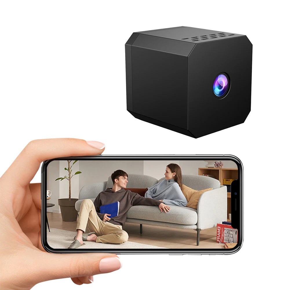 Black portable projector displaying a video on a smartphone held by a hand.