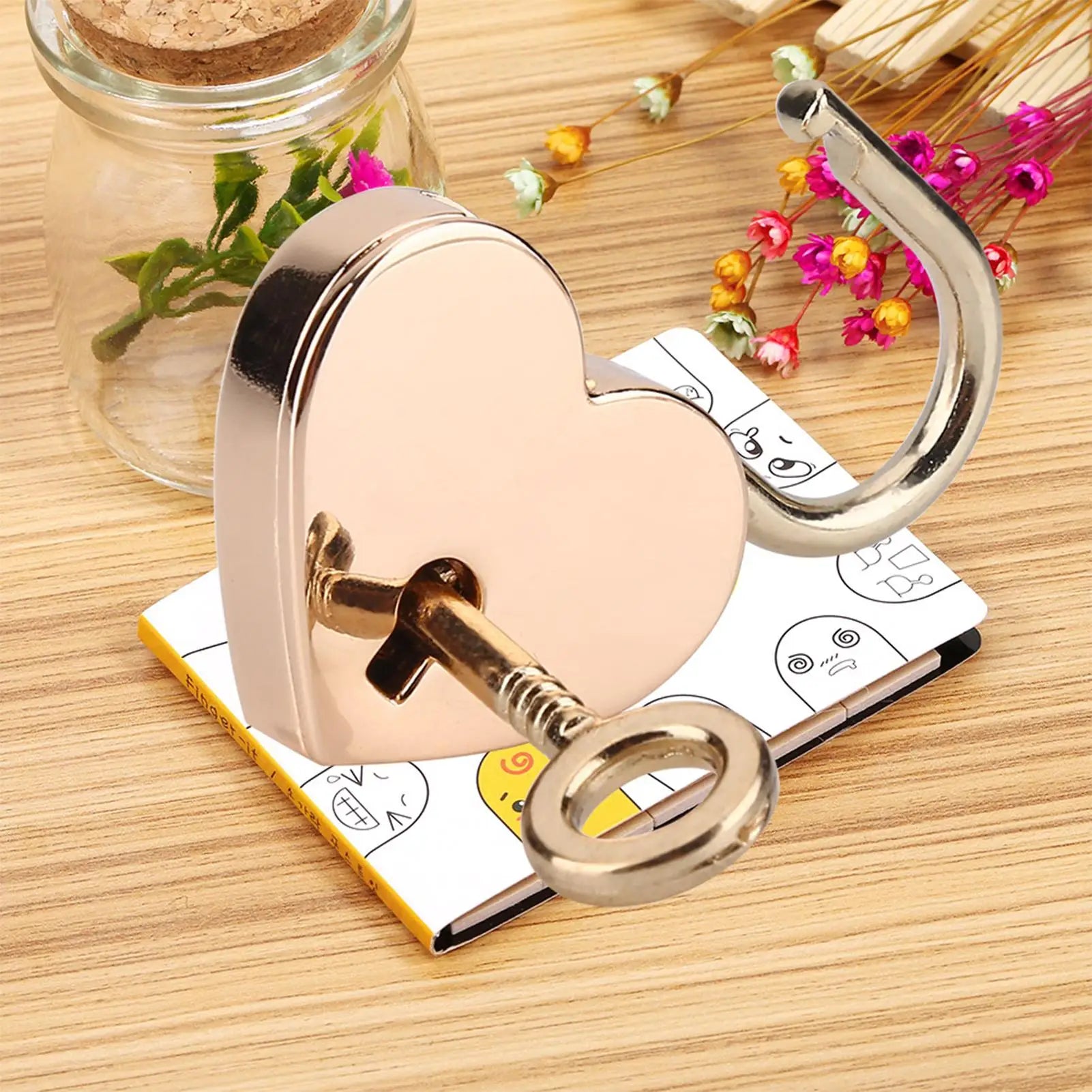 Heart-shaped padlock with a key on a wooden surface with decorative elements