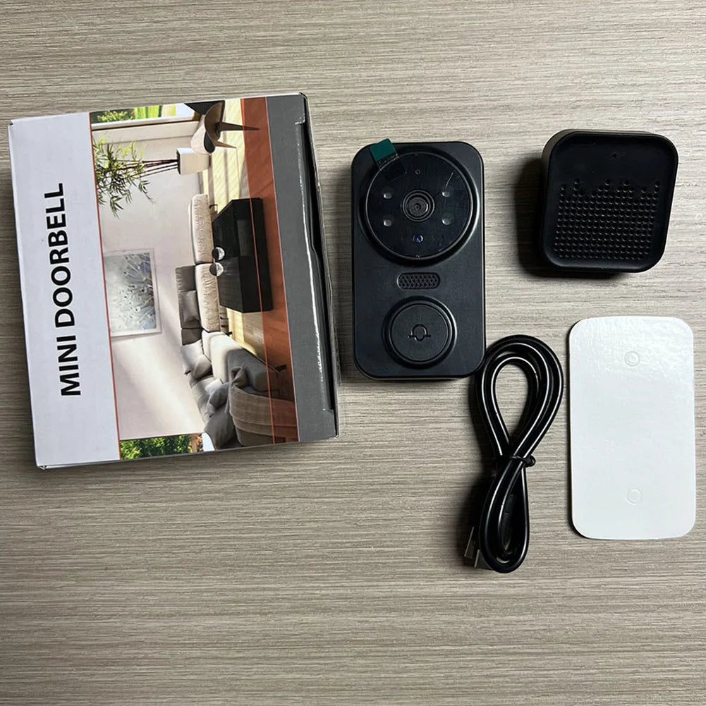 Mini doorbell with packaging, cable, and additional components on a wooden surface
