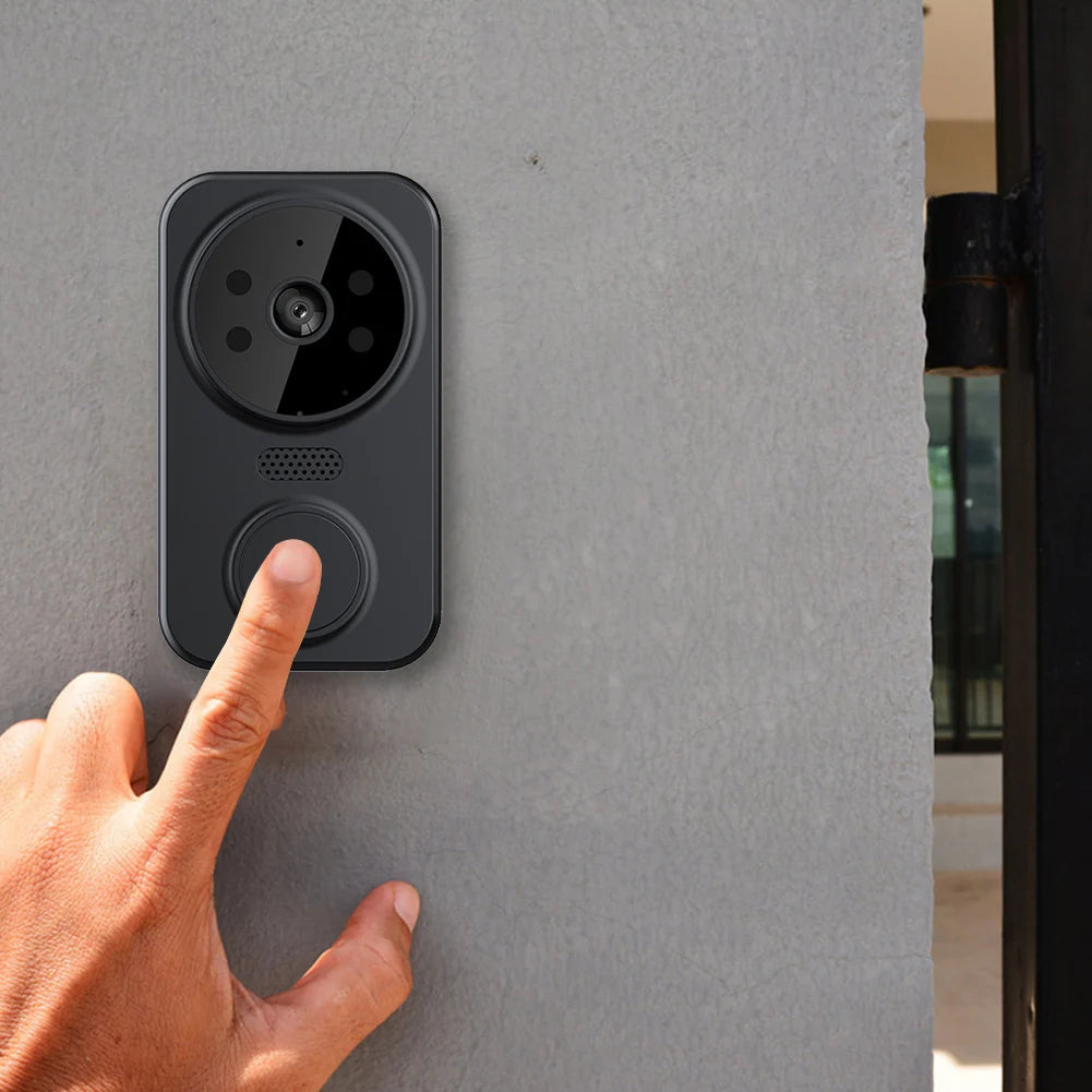 Hand pressing a doorbell button on a gray wall